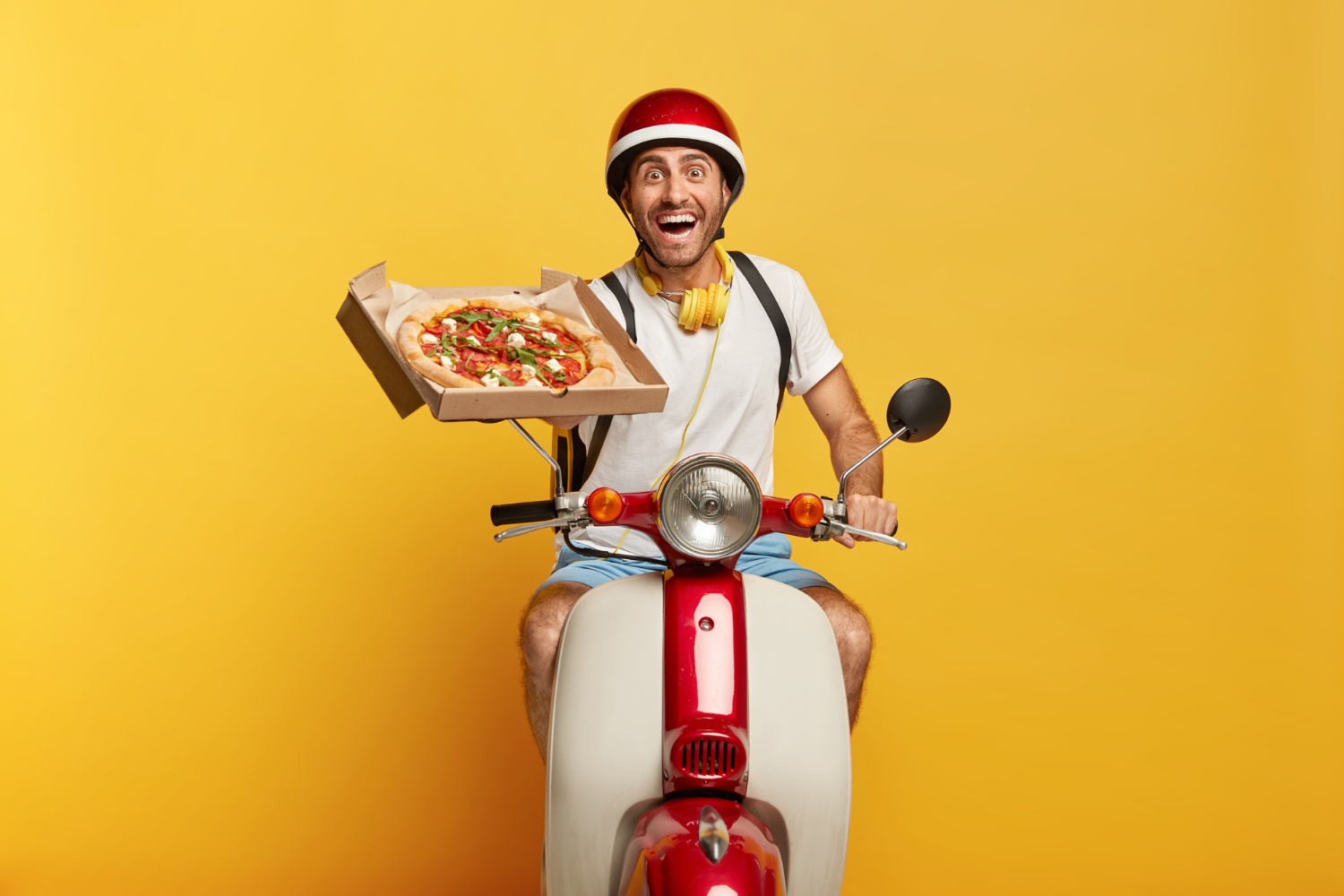 Livreur Wise Eat souriant avec une pizza sur son scooter